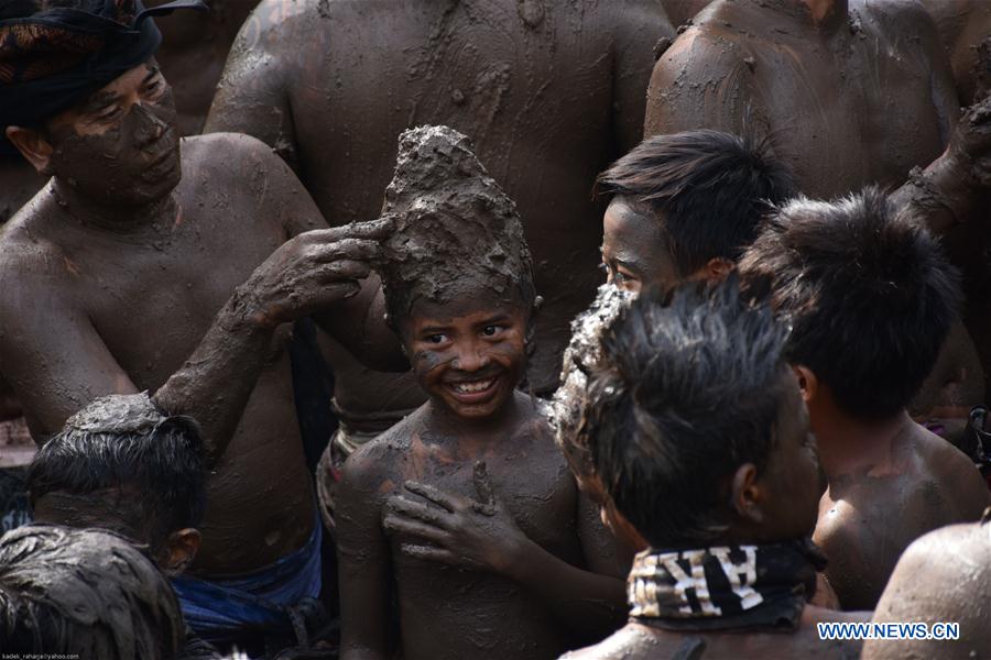 Balinese men put mud on a boy's body during mud baths tradition known as Mebuug-buugan, in Bali, Indonesia, March 29, 2017. The Mebuug-buugan is held a day after Nyepi aimed at neutralizing bad traits. (Xinhua/Kadek) Balinese men put mud on a boy's body during mud baths tradition known as Mebuug-buugan, in Bali, Indonesia, March 29, 2017. The Mebuug-buugan is held a day after Nyepi aimed at neutralizing bad traits. (Xinhua/Kadek)