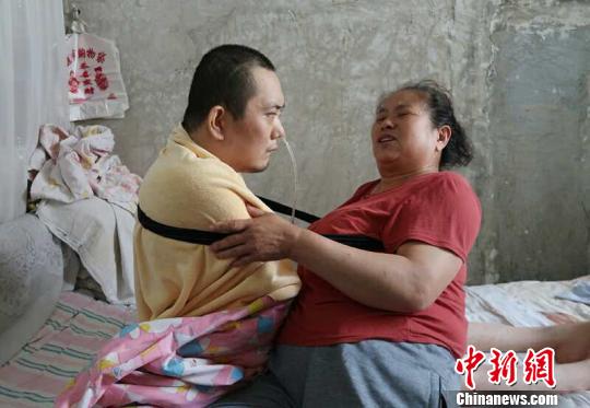 身體日漸衰老的梁青蘭每次幫兒子翻身、坐立，全身的衣物都要濕透一次?！∩忻鱾b 攝