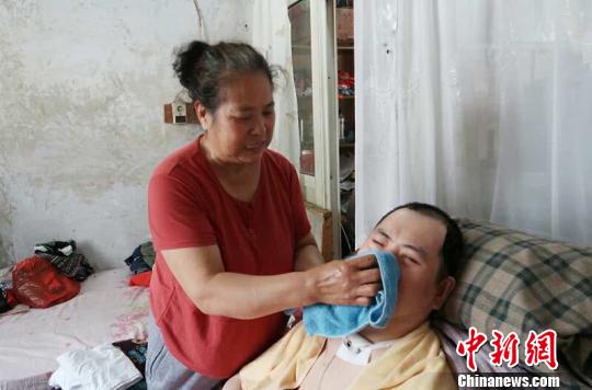 每次喂完食物后，梁青蘭都要仔細(xì)地幫兒子清理干凈?！∩忻鱾b 攝