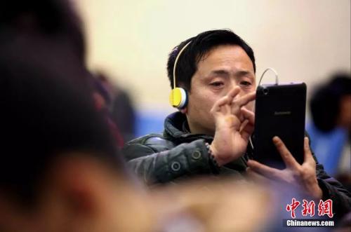 資料圖：候車室內(nèi)，玩手機(jī)的&ldquo;低頭族&rdquo;隨處可見。刷微博、聊微信、玩游戲、看電影，高科技將大多旅客變?yōu)槭謾C(jī)&ldquo;低頭族&rdquo;。<a target='_blank' ><p  align=