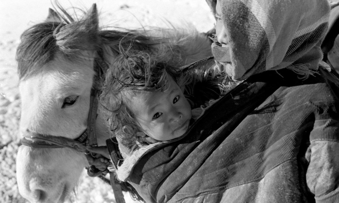 1990年3月，西藏當雄縣納木湖鄉(xiāng)三村女牧民斯卓不畏嚴寒，懷抱幼子，準備到遠處放牧。新華社記者覺果攝
