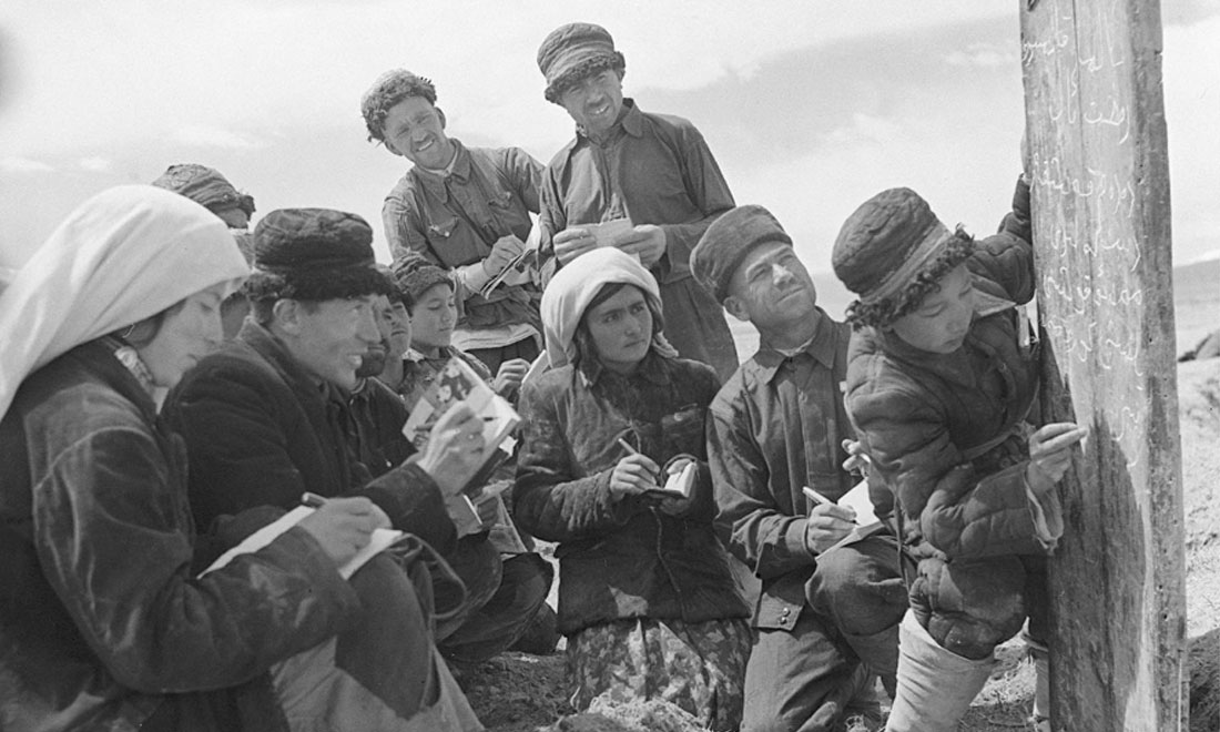 1960年6月，新疆慕士塔格峰下，大人們在小學生幫助下學習文化。新華社記者武純展攝