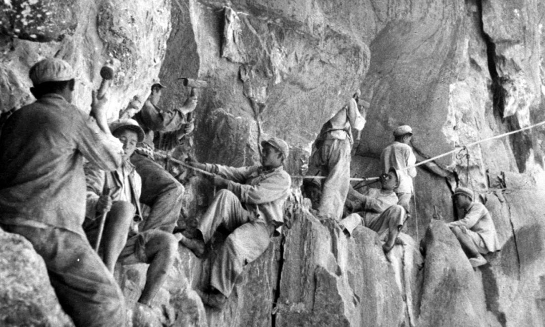 1954年，修筑康藏公路的解放軍戰(zhàn)士們在怒江兩岸的懸崖陡壁上辟山筑路。新華社稿 李萬春、張加里攝