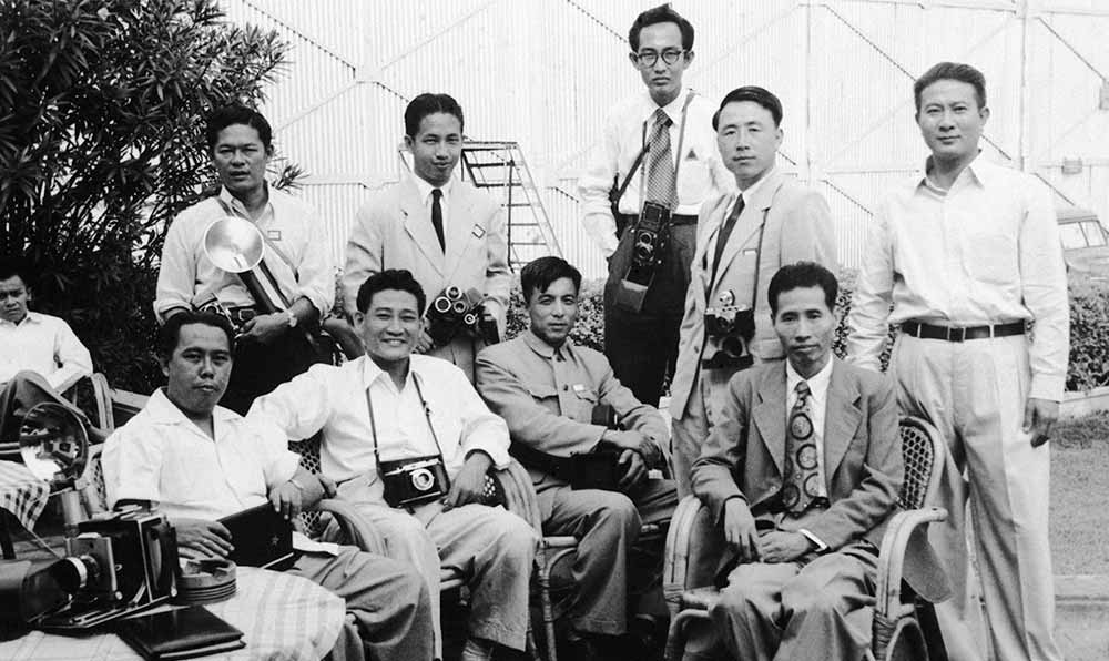 新華社記者錢嗣杰（站立者右二）在采訪會議開幕式后和外國記者在會場外休息。