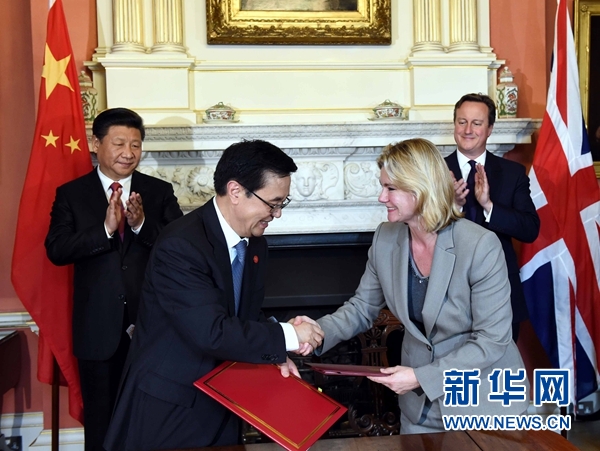 10月21日，國家主席習近平在倫敦唐寧街首相府同英國首相卡梅倫舉行會談。這是會談結(jié)束后，兩國領導人共同見證雙邊合作文件的簽署。新華社記者 饒愛民 攝 