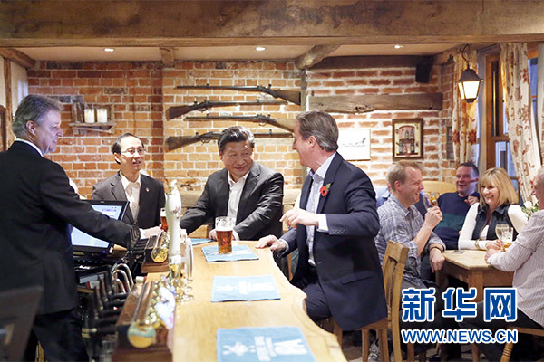 這是會晤結(jié)束后，習(xí)近平在卡梅倫陪同下乘車前往當?shù)匦℃?zhèn)體驗酒吧文化。新華社記者 鞠鵬 攝