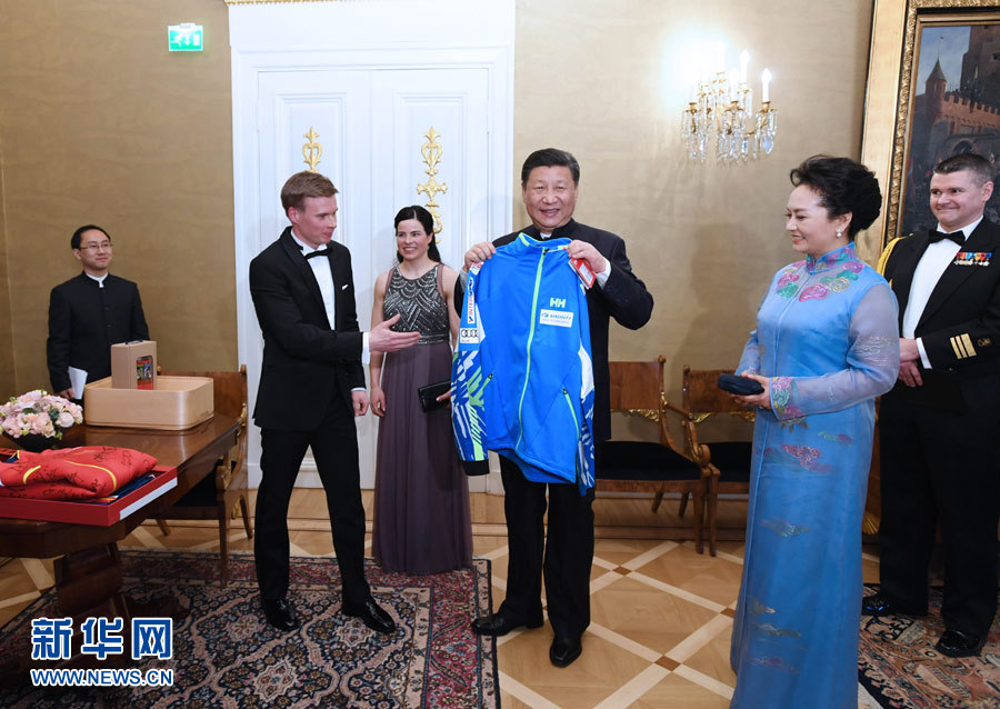 當?shù)貢r間4月5日晚，國家主席習(xí)近平和芬蘭總統(tǒng)尼尼斯托在赫爾辛基共同會見剛剛參加完2017年世界花樣滑冰錦標賽的中芬兩國冰雪運動員代表。習(xí)近平夫人彭麗媛和尼尼斯托夫人豪吉歐參加會見。這是芬蘭運動員向習(xí)近平和夫人彭麗媛贈送運動衣。新華社記者 饒愛民 攝